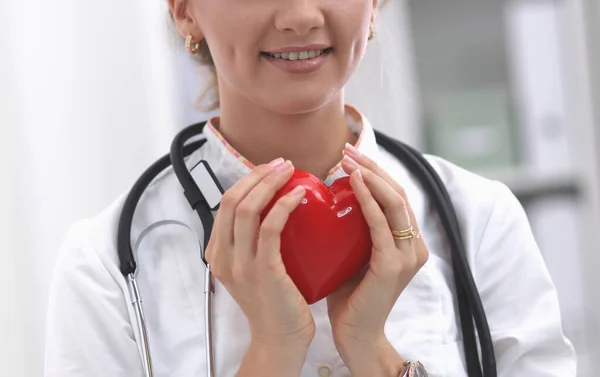 Doktor se stetoskopem drží srdce, izolované na bílém pozadí — Stock fotografie