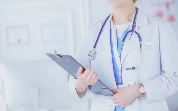 Smiling female doctor with a folder in uniform standing — Stok Foto