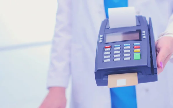 Doctor is holding payment terminal in hands. Paying for health care. Doctor