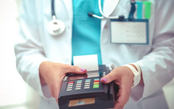 De dokter houdt de betaalterminal in handen. Betalen voor de gezondheidszorg. Dokter. — Stockfoto