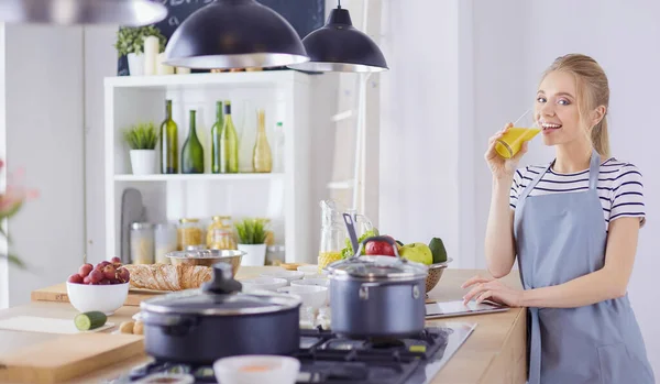 Attraktive Frau mit einem Glas Orangensaft in der Küche — Stockfoto