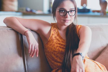 Kanepede oturan gülümseyen kadın portresi. Günlük tarz kapalı çekim.