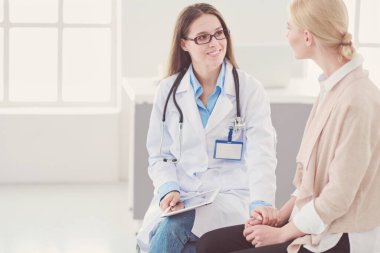 Doktor ve hasta masada otururken bir şey tartışıyorlar. İlaç ve sağlık hizmetleri kavramı