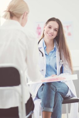 Doktor ve hasta masada otururken bir şey tartışıyorlar. İlaç ve sağlık hizmetleri kavramı