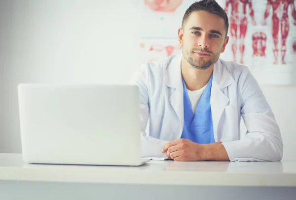 Porträt eines männlichen Arztes mit Laptop am Schreibtisch in der Arztpraxis — Stockfoto