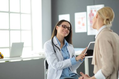 Doktor ve hasta masada otururken bir şey tartışıyorlar. İlaç ve sağlık hizmetleri kavramı