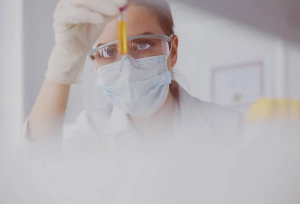 Femme chercheuse entourée de flacons et flacons médicaux, isolée sur du blanc — Photo