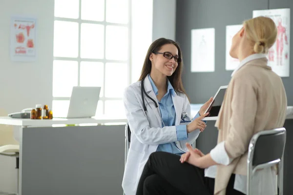 Doctor y paciente discutiendo algo mientras están sentados en la mesa. Concepto de medicina y salud — Foto de Stock