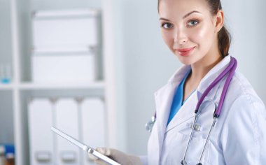 Kadın doktor hastanede dosyayla bekliyor.