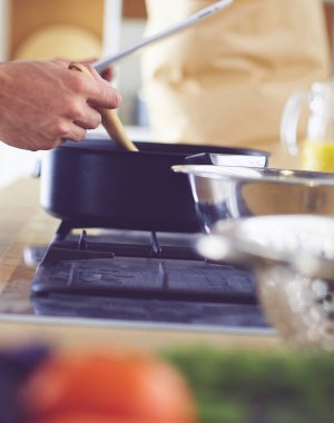 Dijital tablet ve yemek pişirme tarifine uyan bir adam evdeki mutfakta lezzetli ve sağlıklı yemekler pişiriyor.