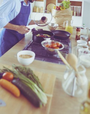 Adam ev mutfağında lezzetli ve sağlıklı yemekler hazırlıyor.