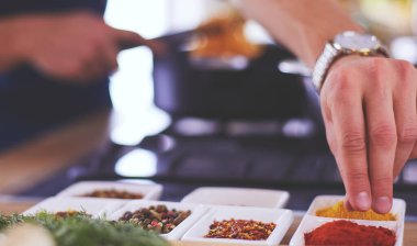 Adam ev mutfağında lezzetli ve sağlıklı yemekler hazırlıyor.