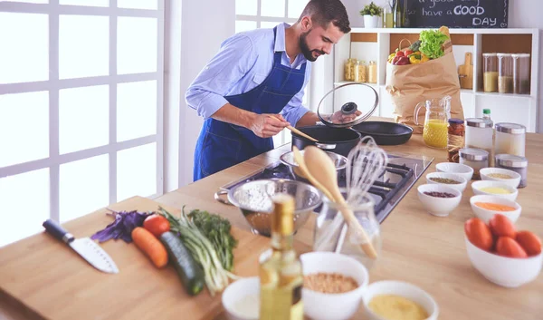 Seorang pria menyiapkan makanan lezat dan sehat di dapur rumah — Stok Foto