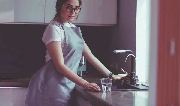 Egy nő, aki egy pohár vizet tölt meg rozsdamentes acélból vagy króm csapból vagy csapból — Stock Fotó