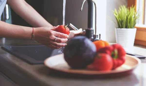 Жінка миє помідори на кухні раковина крупним планом — стокове фото