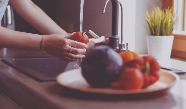 Woman washing tomatoes in kitchen sink close up — Stock Photo, Image