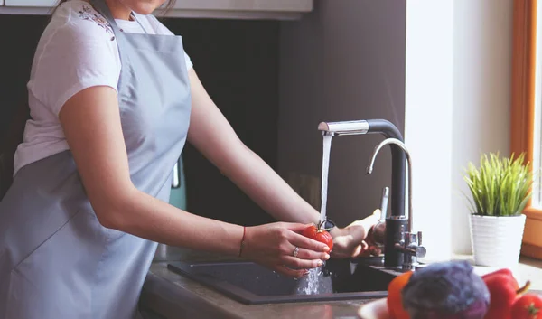 Händerna på kvinna tvätta grönsaker på hennes kök — Stockfoto