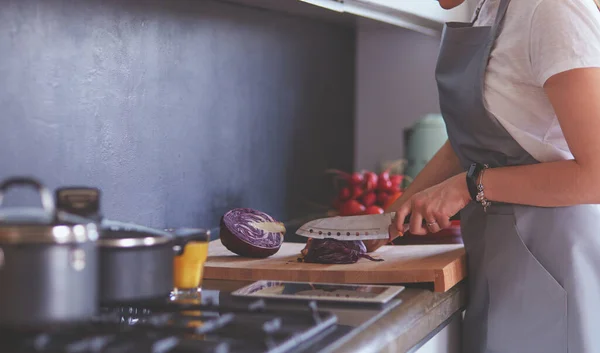 Yeni mutfakta yemek pişiren kadın sebzelerle sağlıklı yemekler yapıyor. — Stok fotoğraf