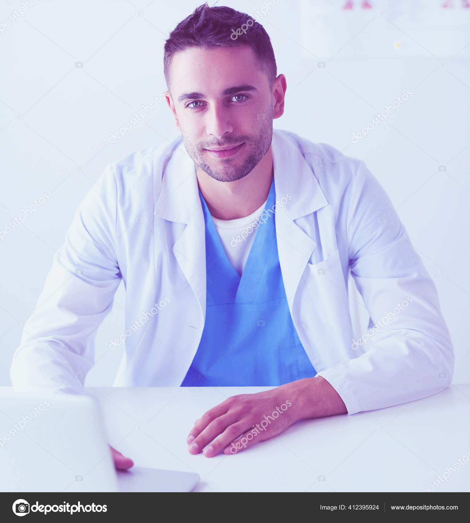 Retrato de um médico do sexo masculino com laptop sentado na mesa no  consultório médico. — Foto © lenetssergey #412395924