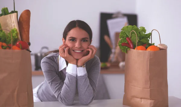 Ritratto di una donna sorridente che cucina nella sua cucina seduta — Foto Stock