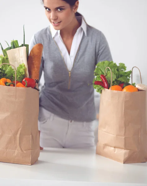 Young woman holding grocery shopping bag with vegetables Standing in the kitchen — Stock Photo, Image