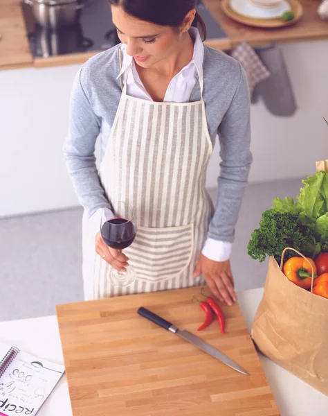 Žena s nákupními taškami v kuchyni doma, stojí u stolu — Stock fotografie