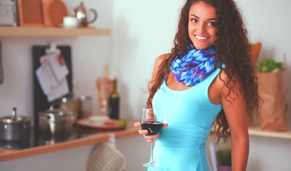 Söt kvinna dricker lite vin hemma i köket — Stockfoto