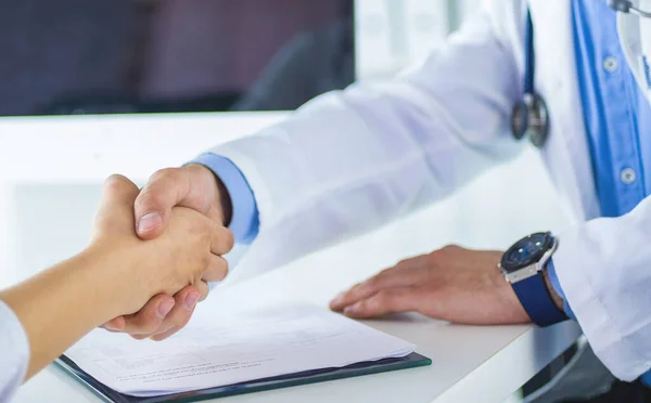 Doctor shaking hands to patient in the office at desk — Stock Photo, Image