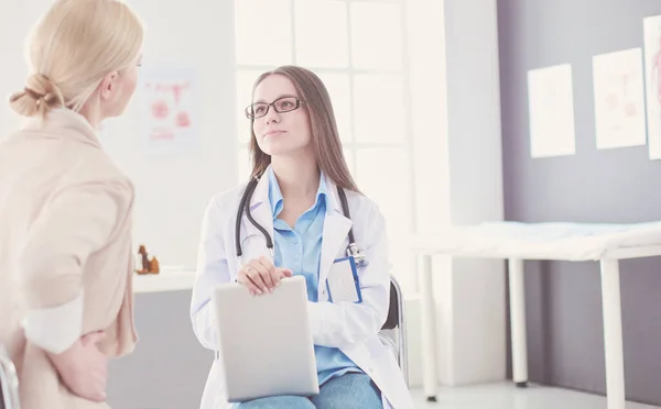 Dokter en patiënt bespreken iets terwijl ze aan tafel zitten. Begrip "geneeskunde en gezondheidszorg" — Stockfoto