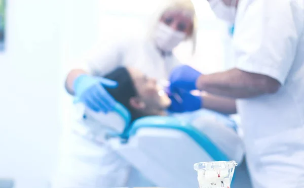 Tandläkare och hans assistent utför en grundlig undersökning — Stockfoto