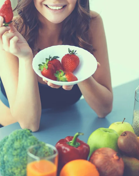 笑っている女性がイチゴを食べている。女性の顔の肖像画を閉じる — ストック写真