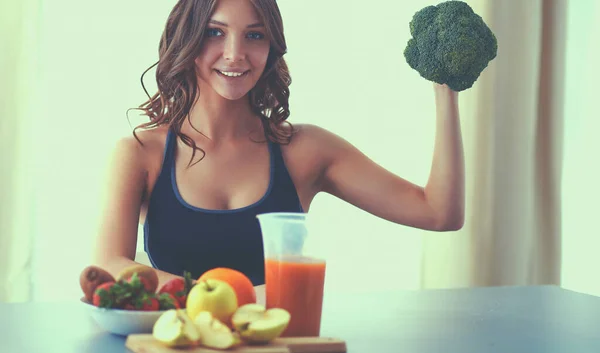 Meisje in de keuken op het bureau met fruit en glazen sap — Stockfoto