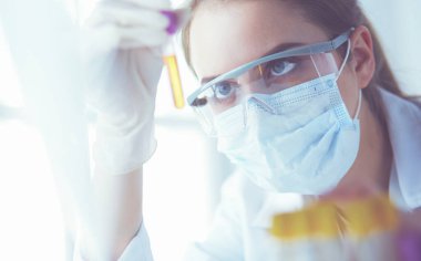 Modern laboratuvar veya hastanede plastik tıbbi tüplerle çalışan araştırmacı, doktor, bilim adamı veya laboratuvar asistanı.