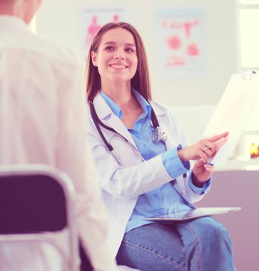 Doktor ve hasta masada otururken bir şey tartışıyorlar. İlaç ve sağlık hizmetleri kavramı