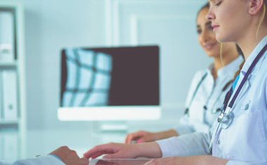 Tıbbi ekip masada oturup tartışıyor.