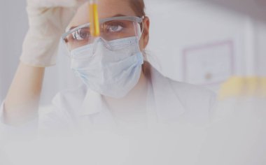 Kadın araştırmacı, beyaz şişeler ve şişelerle çevrili.