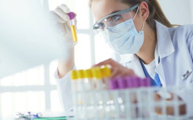Modern laboratuvar veya hastanede plastik tıbbi tüplerle çalışan araştırmacı, doktor, bilim adamı veya laboratuvar asistanı