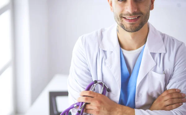 Portret lekarza z laptopem siedzącego przy biurku w gabinecie lekarskim — Zdjęcie stockowe