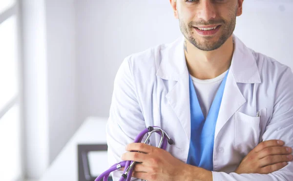 Retrato de un médico varón con portátil sentado en el escritorio en el consultorio médico —  Fotos de Stock