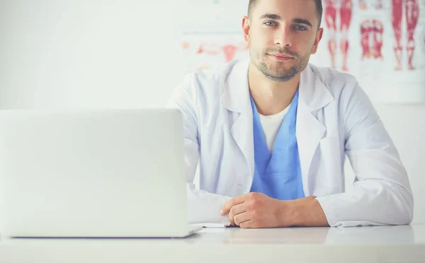 Porträt eines männlichen Arztes mit Laptop am Schreibtisch in der Arztpraxis — Stockfoto