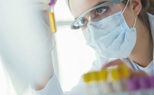 Retrato de una asistente de laboratorio bastante femenina analizando una muestra de sangre en el hospital — Foto de Stock