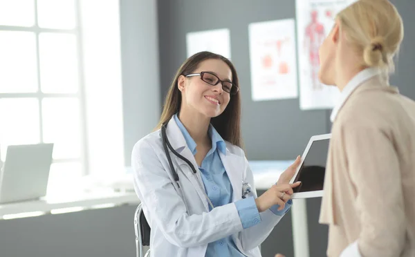 Dokter en patiënt bespreken iets terwijl ze aan tafel zitten. Begrip "geneeskunde en gezondheidszorg" — Stockfoto