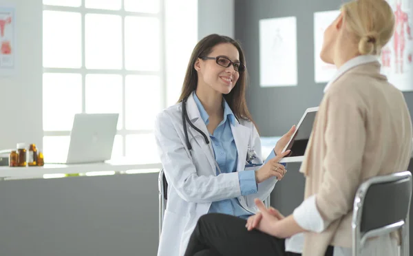 Dokter en patiënt bespreken iets terwijl ze aan tafel zitten. Begrip "geneeskunde en gezondheidszorg" — Stockfoto