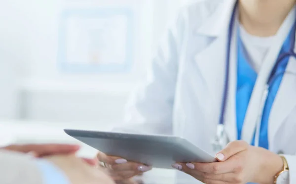 Médico femenino usando tableta en el vestíbulo del hospital, sonriendo —  Fotos de Stock