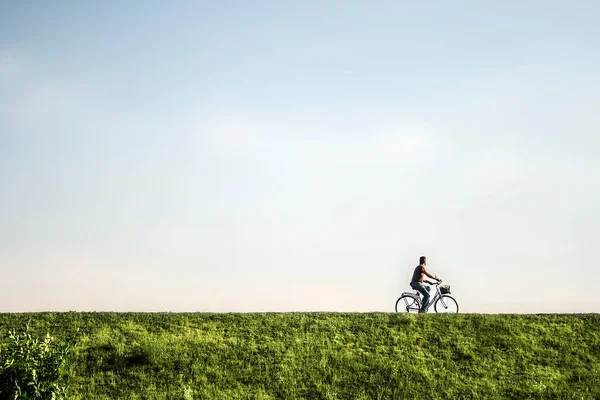 在清澈的绿地里骑自行车的人 — 图库照片