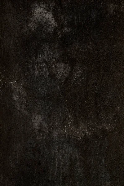 Old black wall surface with damp, grungy background or texture