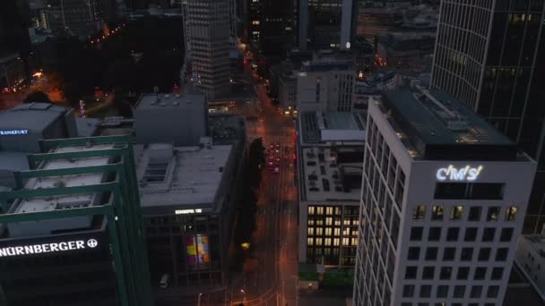 AERIAL: Вид на центр Франкфурта-на-Майне сразу после заката с городскими огнями и видом через Skyscrapers — стоковое видео