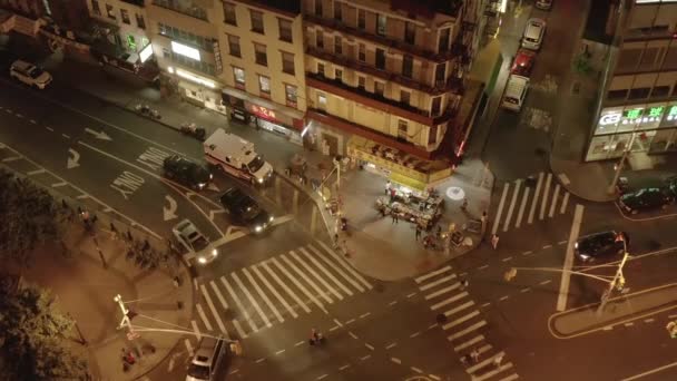 AERIAL: Zavedení stropní střelecké křižovatky se silničním provozem a Street Food Market v noci v čínské čtvrti, Manhattan, New York City — Stock video