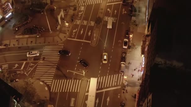 AERIAL: Nad głową w dół Po samochodzie skręca w lewo na skrzyżowaniu dróg w nocy w Chinatown, Manhattan, Nowy Jork — Wideo stockowe