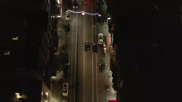 AERIAL: režie shora dolů Sledovat záběr vozidla auto jízdy na tmavé silnici v noci v čínské čtvrti, Manhattan, New York City — Stock video